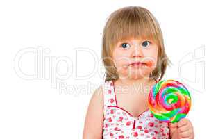 Baby girl eating a sticky lollipop