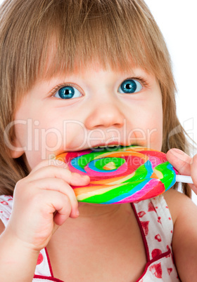 Baby girl eating a sticky lollipop