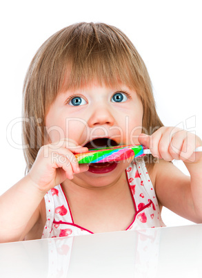 Baby girl eating a sticky lollipop