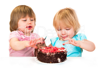 Two little baby girl eating cake