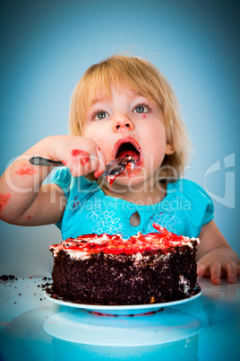 Little baby girl eating cake