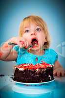 Little baby girl eating cake