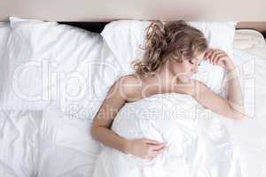 Young blonde woman sleeping in bed