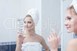 Woman with glass in bathroom