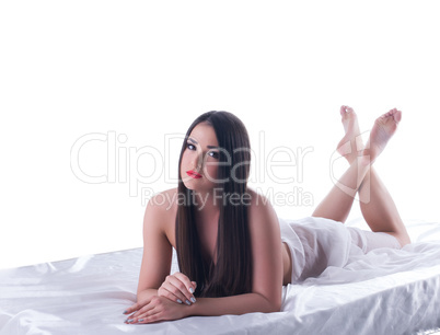 Beauty brunette woman lying on silk bed isolated
