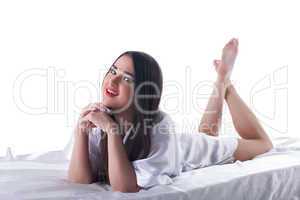 Pretty brunette woman with long hair lying on bed