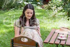 Junge Frau mit Tablet PC im Garten, young woman with tablet PC i