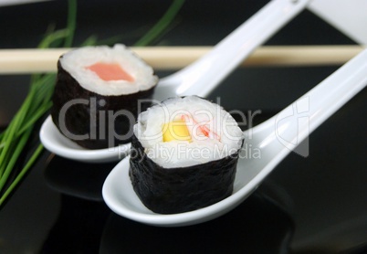 Sushi rolls on a black dish