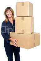 Friendly delivery woman with three packed cartons