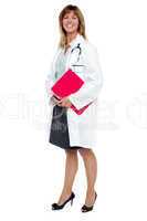 Smiling female physician holding clipboard