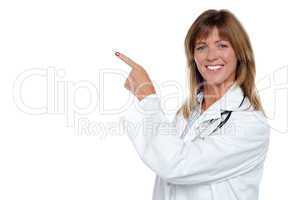 Cheerful female doctor pointing away