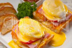 eggs benedict on bread with tomato and ham