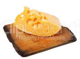 Piece of cheese on old wooden board