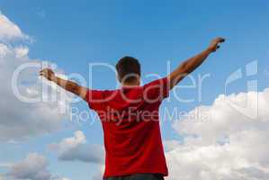 Young man staying with raised hands