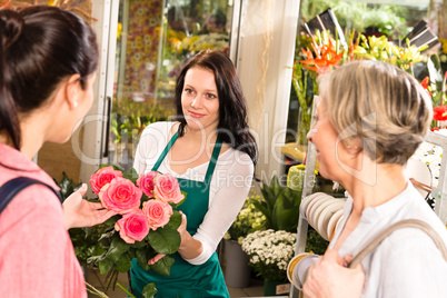 Happy florist woman showing roses flowers customers