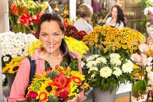 Cheerful florist woman showing colorful flowers market