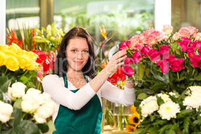 Happy young woman arranging flowers florist shop
