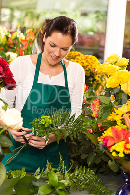 Young florist preparing flowers bouquet shop store