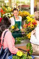Young woman florist cutting flower shop customers