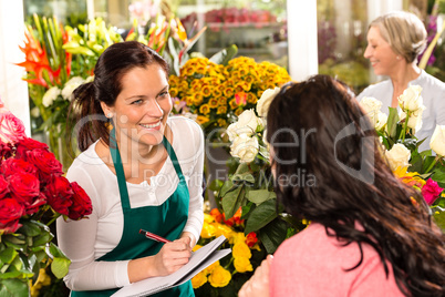 Happy florist writing flower shop talking customer