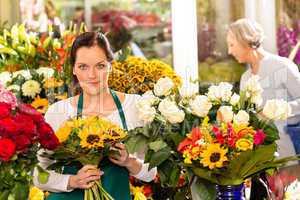 Woman florist selling sunflowers bouquet flower shop