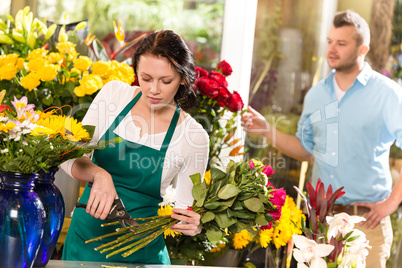 Woman florist cutting flowers shop bouquet man