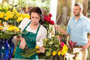 Woman florist cutting flowers shop bouquet man