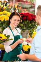 Smiling florist man customer buying flowers card