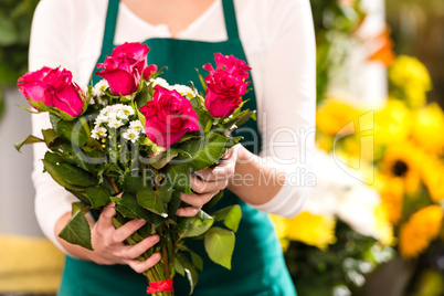 Florist hands showing red roses bouquet flowers