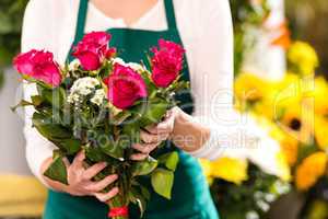 Florist hands showing red roses bouquet flowers