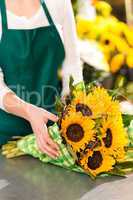 Florist preparing sunflowers bouquet flower shop assistant