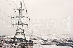 Electricity pylons on snow covered moors
