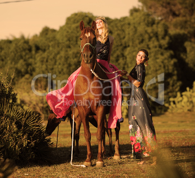 two woman riding horse