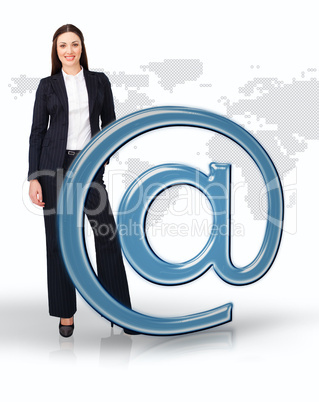Businesswoman standing by email at symbol