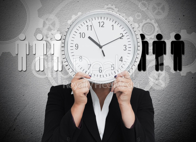 Businesswoman hiding her face with wall clock