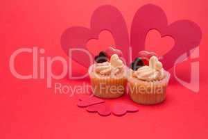 Two valentines cupcakes with  five heart decorations