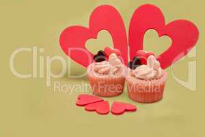 Two valentines cupcakes with  five heart decorations