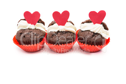 Three chocolate valentines cupcake with heart decorations and cr