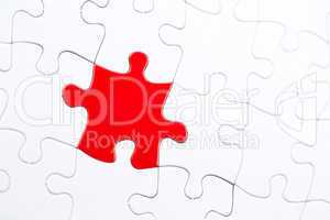 White jigsaw puzzle with one red piece