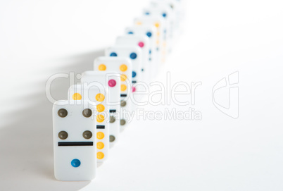 Line of colourful dominoes on white background