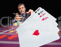 Gambler holding whiskey at poker table with digital hand of card