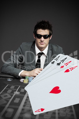 Gambler in sunglasses with digital cards in foreground