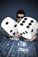 Gambler in sunglasses with digital dice in foreground