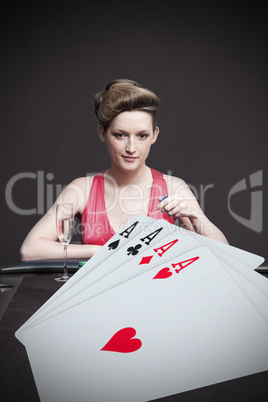 Attractive gambler betting on hand of four aces