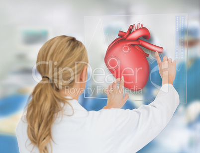 Blonde doctor consulting heart diagram on touchscreen display