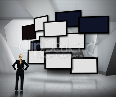 Group of blank screens on grey background with businesswoman loo