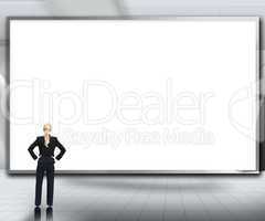 Businesswoman looking up at large blank screen