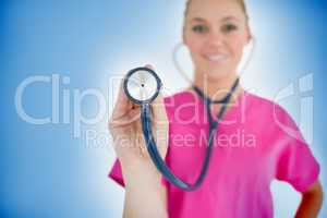 Smiling nurse holding up stethoscope