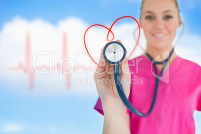 Happy nurse holding up stethoscope to heart design