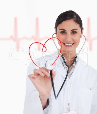 Happy doctor holding up stethoscope to red heart design